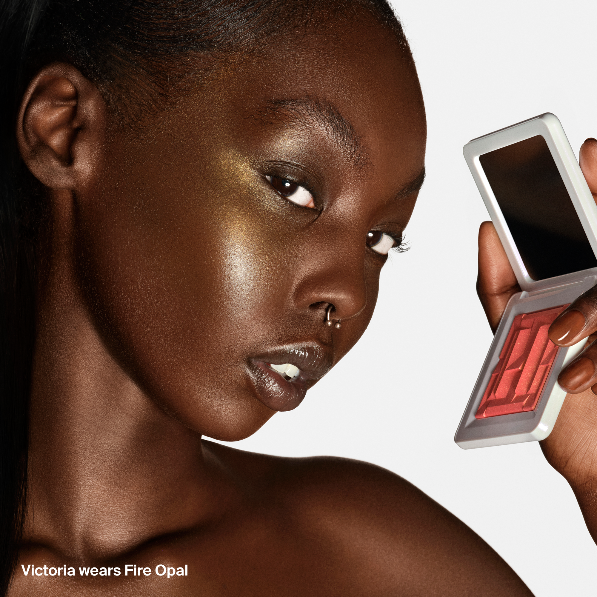Model met Haus Labs Bio-Radiant Gel-Powder Highlighter in Fire Opal